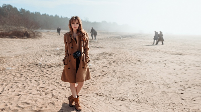 Woman with camera on a sandy beach