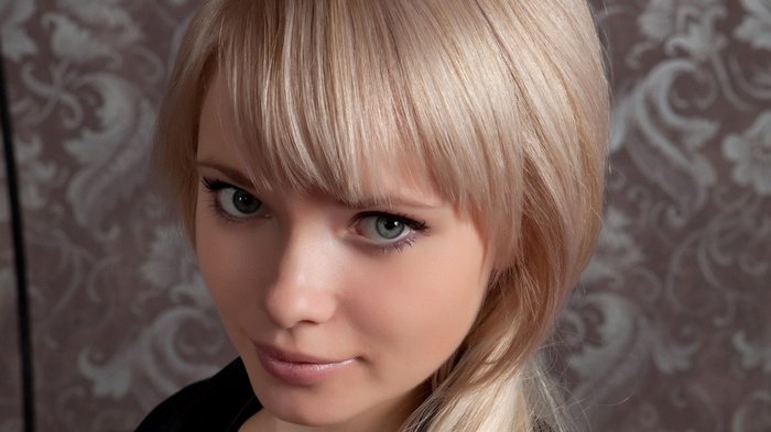 Close-up of a blonde woman with green eyes