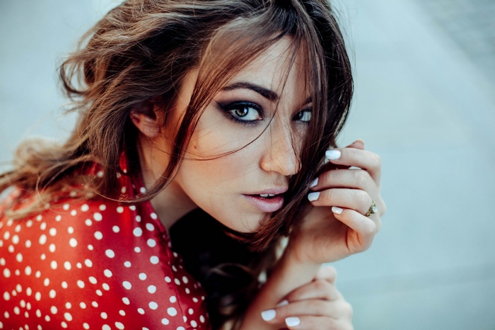 Woman with dark hair and red polka dot dress