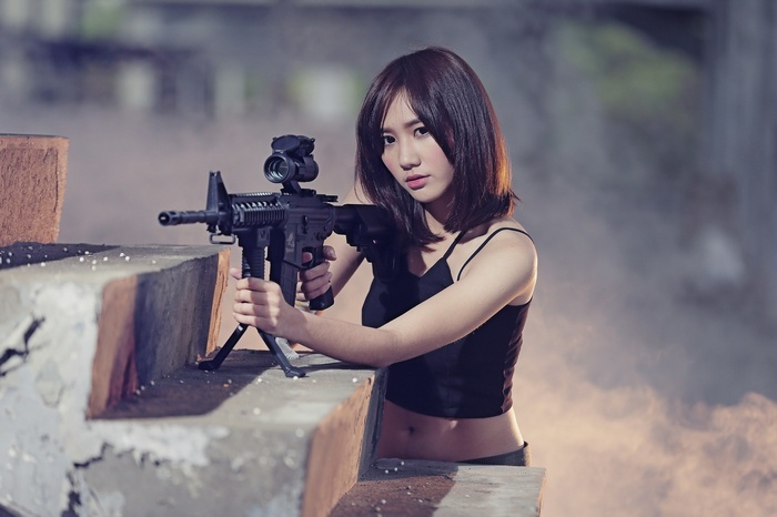 Asian woman holding a rifle with a scope