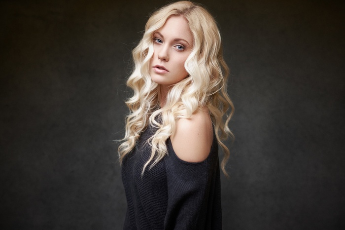 Woman with blonde wavy hair and blue eyes