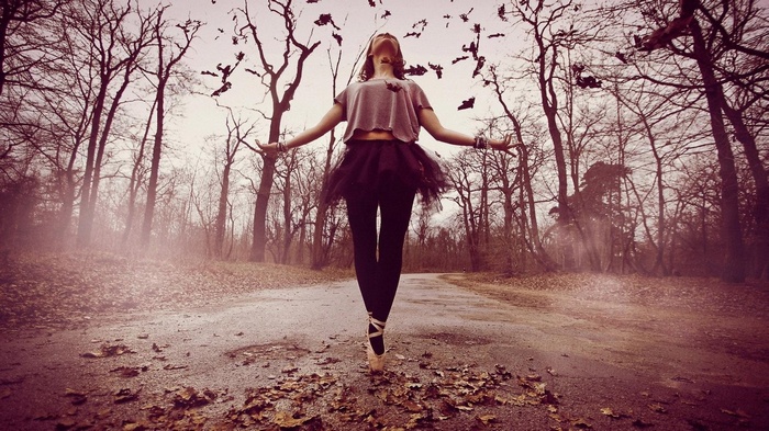 Ballerina dancing on a road in a forest