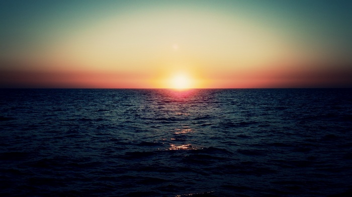 Sunset over the ocean with calm waves