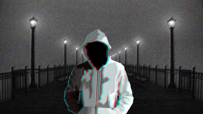 Figure in a hoodie on a foggy pier at night