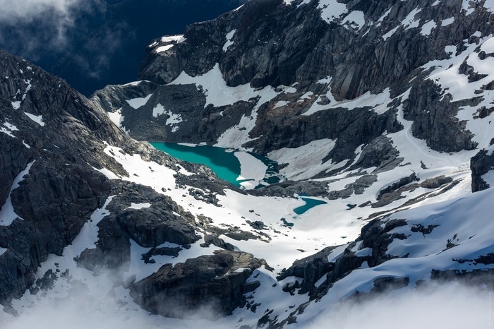 Turquoise lake nestled in snowy mountains