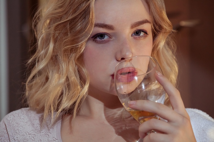 Daniel Sea with blonde hair drinks from a glass