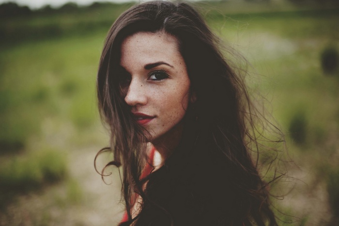 Woman with long hair and freckles outdoors