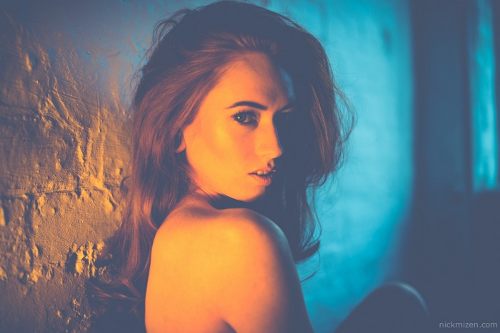 Redhead woman with long hair against a textured wall