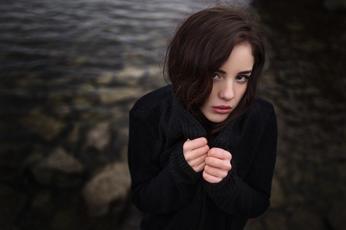 Woman in black sweater by the water