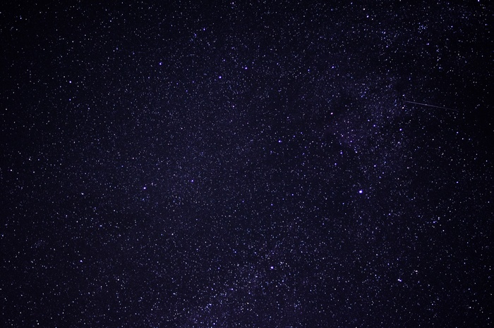Starry night sky with a meteor shower