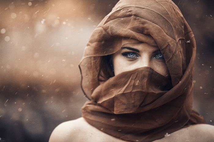 Woman with blue eyes wearing a brown scarf