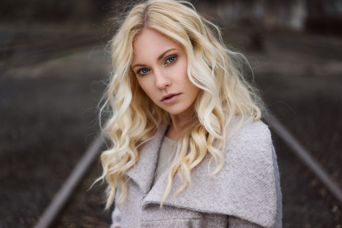 Woman with blonde wavy hair and blue eyes outdoors