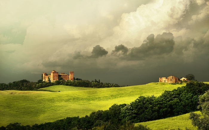 Castle on a hill in Tuscany under stormy clouds