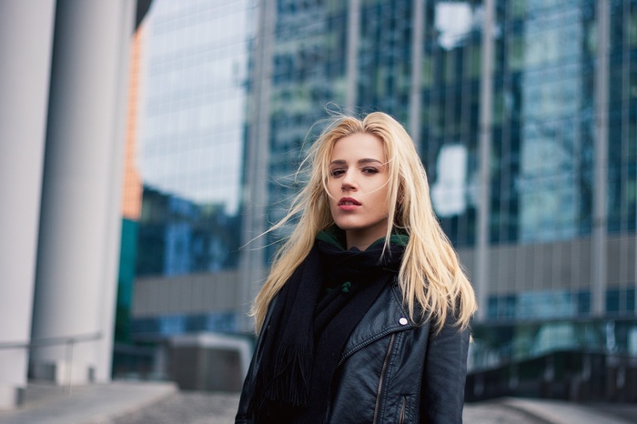 Woman with blonde hair wearing a scarf and leather jacket