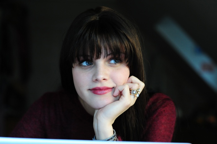 Woman with bangs and blue eyes looking away