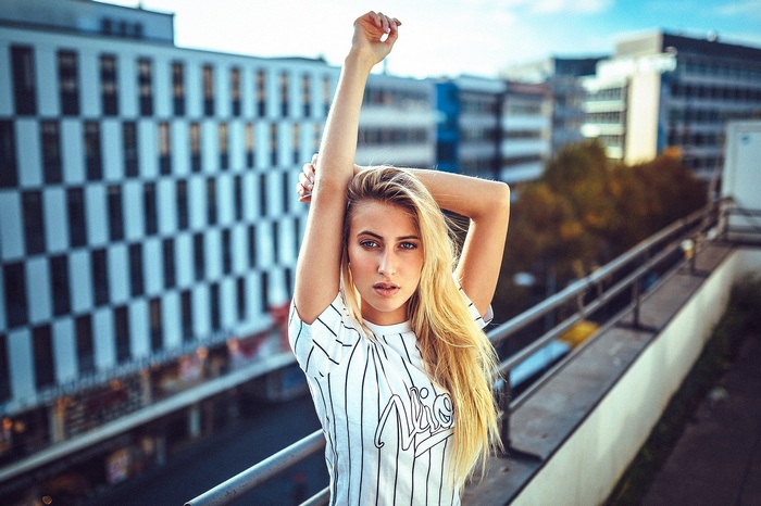 Woman with arms up on urban rooftop
