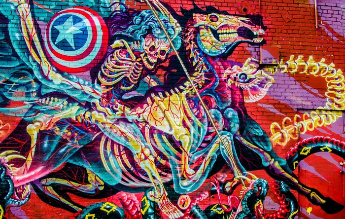 Graffiti artwork of skeletal figures on a brick wall
