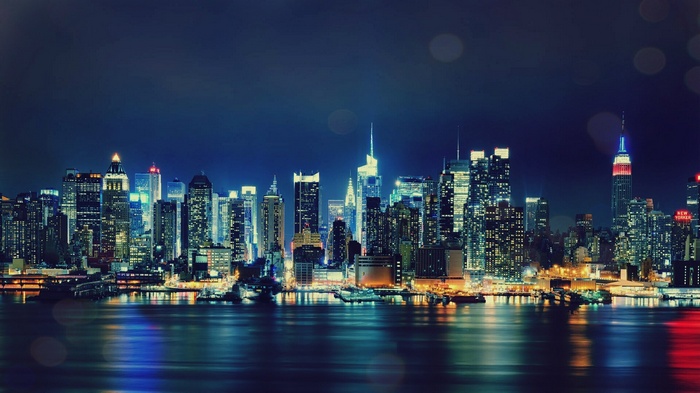 New York City skyline at night with water reflections
