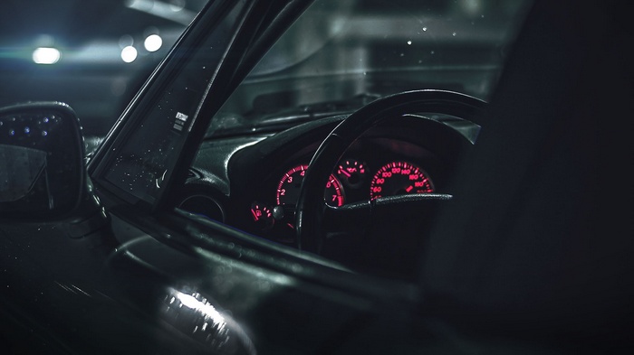 Car interior with glowing red dashboard lights
