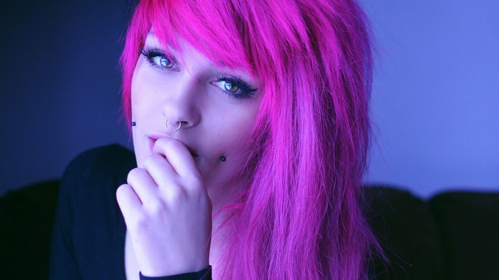 Woman with bright pink hair and piercings