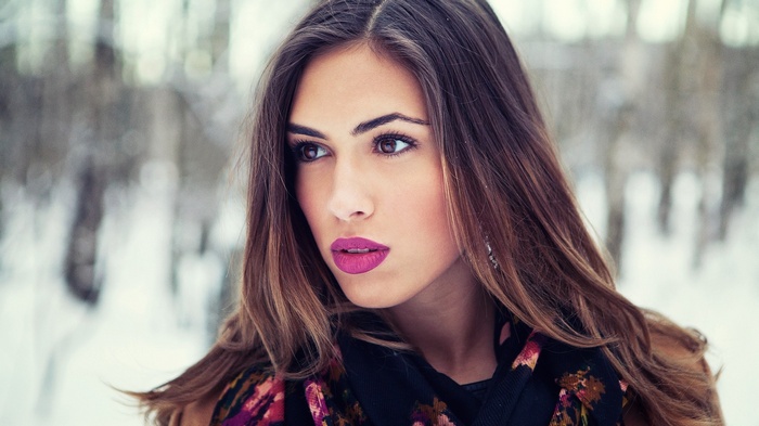 Woman with pink lipstick in winter forest