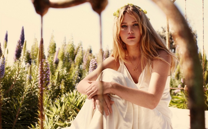 Jennifer Lawrence wearing a flower crown and white dress