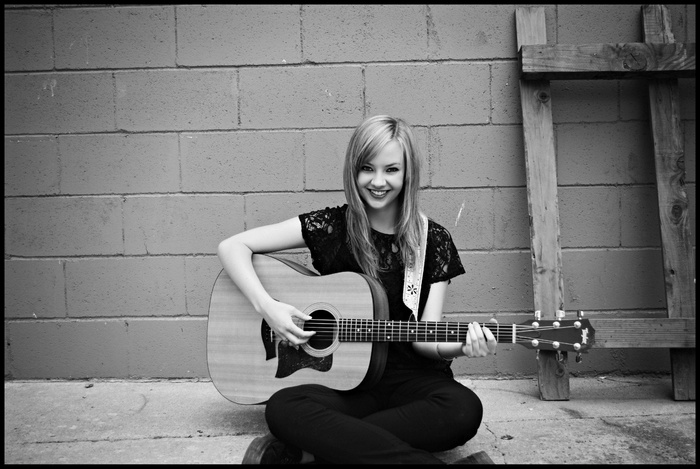 Laura Brehm playing acoustic guitar