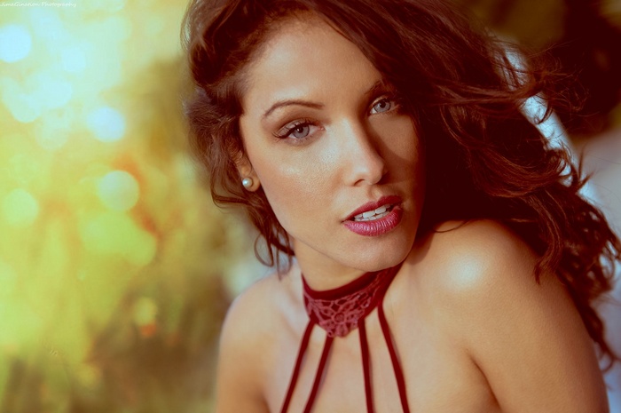 Woman with curly hair and blue eyes looking at viewer