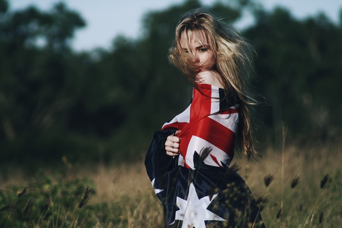 Woman wrapped in Australian flag in a field