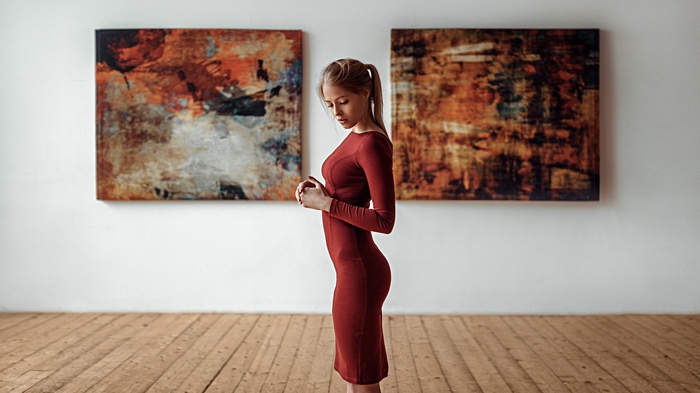 Woman in red dress in art gallery with paintings