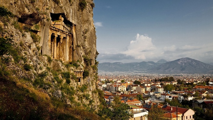 Ancient Lycian rock tombs overlooking a Turkish city