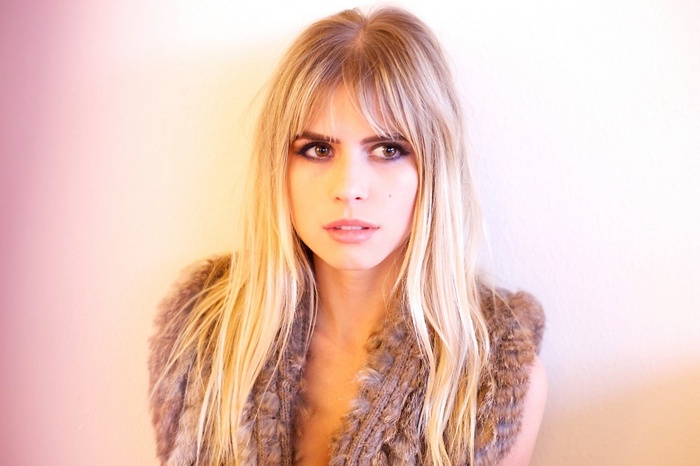 Carlson Young wearing a fur vest