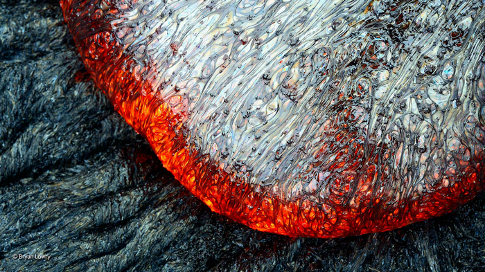 Close-up of flowing lava on dark volcanic rock