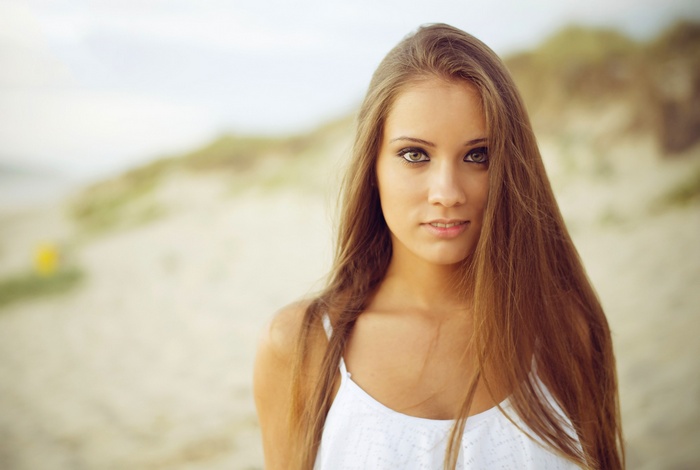 Woman with long brown hair on a beach