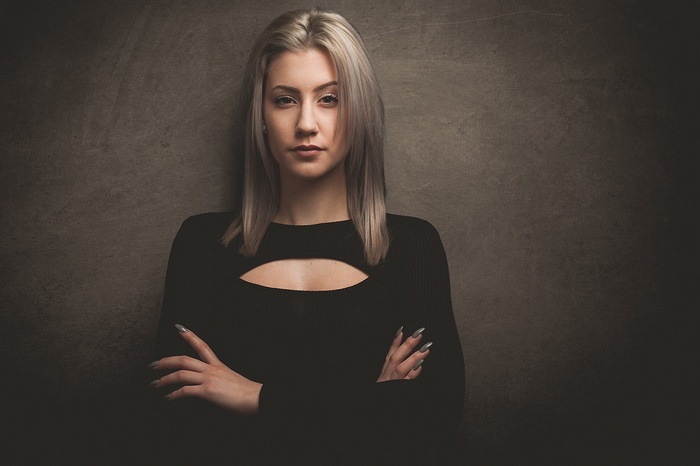 Woman with arms crossed against textured background