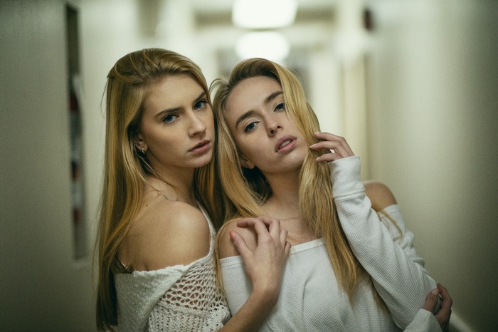 Two blonde women posing in a hallway