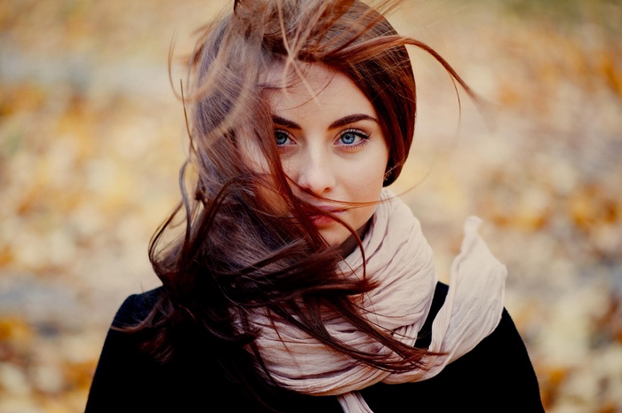 Woman with red hair and blue eyes in the wind