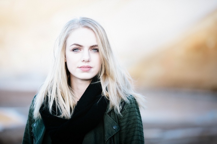 Woman with blonde hair and blue eyes wearing a scarf