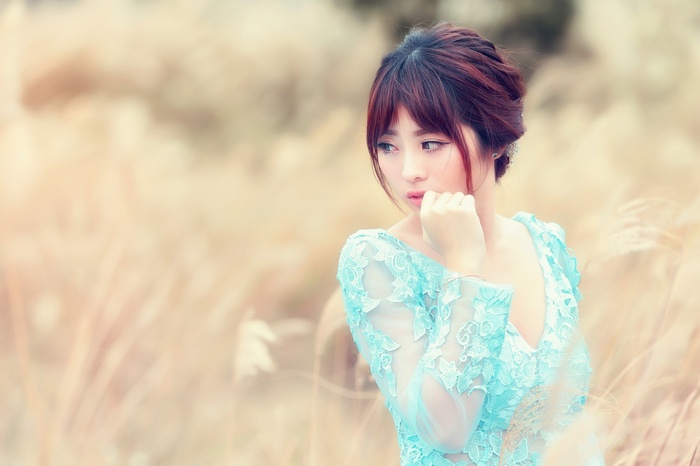 Asian woman in a blue lace dress outdoors