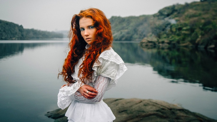 Redhead woman in white dress by the water