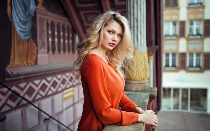 Woman in orange dress on a balcony