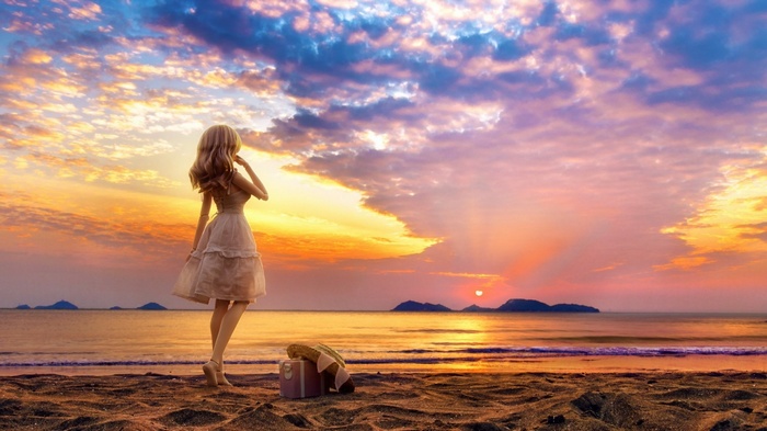 Doll on a beach at sunset with a suitcase