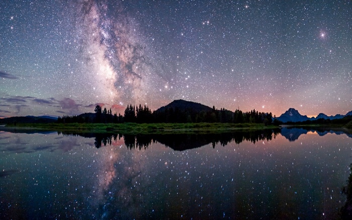 Milky Way over a lake with mountains and reflection
