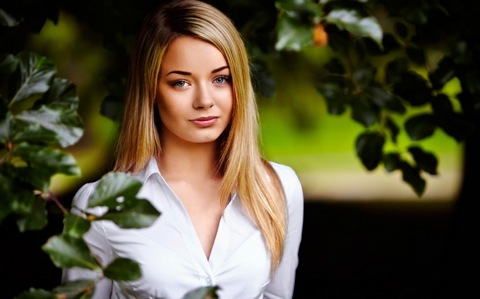 Woman with blonde hair and blue eyes in a white shirt