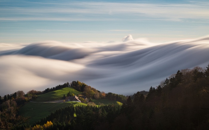Rolling clouds over green hills and forest