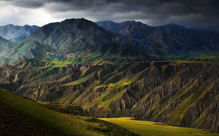 Sunlight on mountains and canyons in China under storm clouds