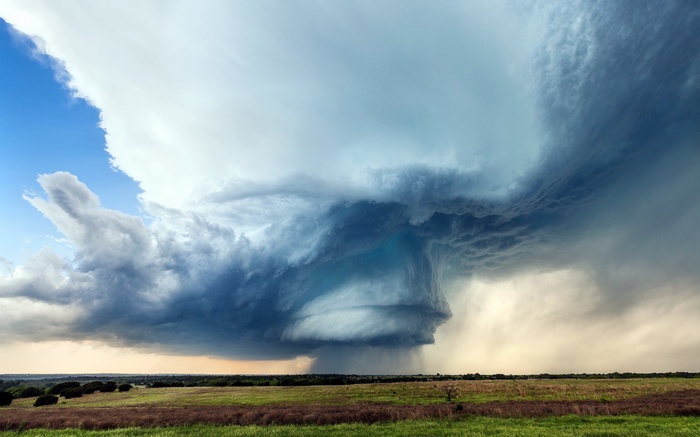 Dramatic storm clouds over a grassy field