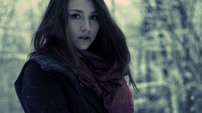 Woman in winter with scarf looking at viewer