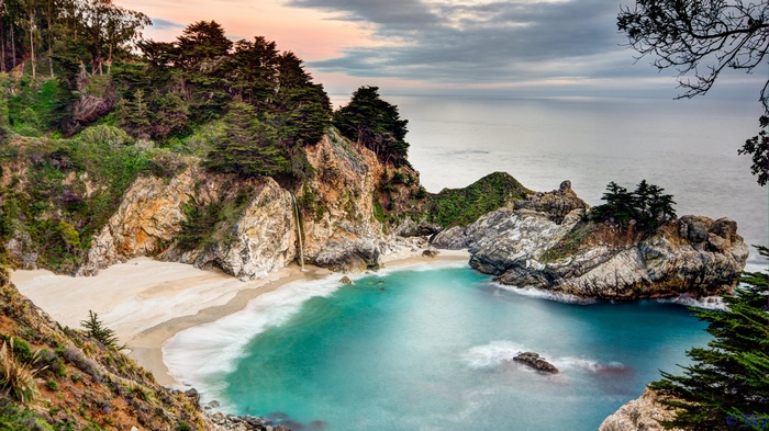 McWay Falls waterfall cascading onto a sandy beach in Big Sur