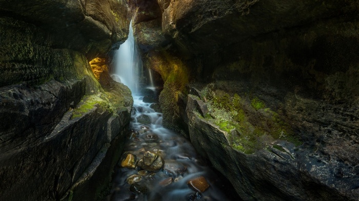 Waterfall cascading through a mossy gorge in Scotland